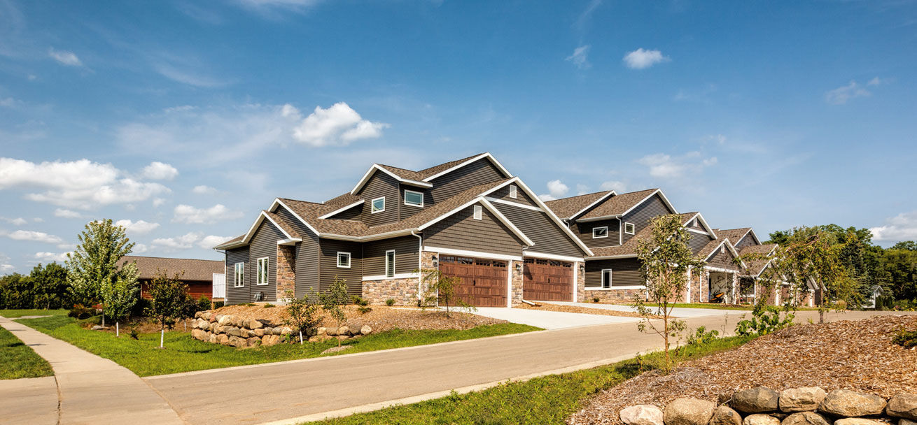 Row of new townhome-style buildings with landscaping