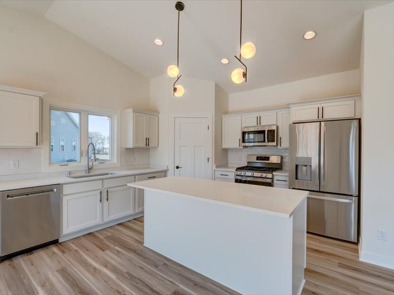 Kitchen with stainless refrigerator and island